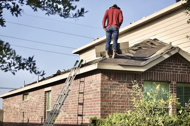 Professional roofer working on a residential roof in Macland
